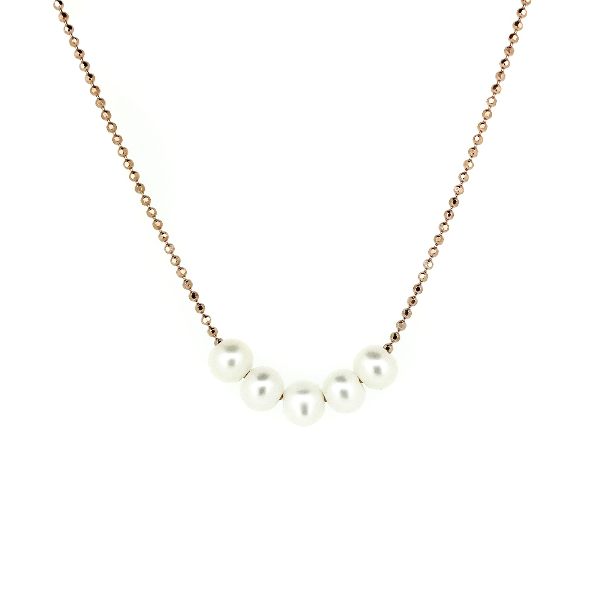 A rose gold vermeil necklace with five pearls placed along the chain, worn by a model.