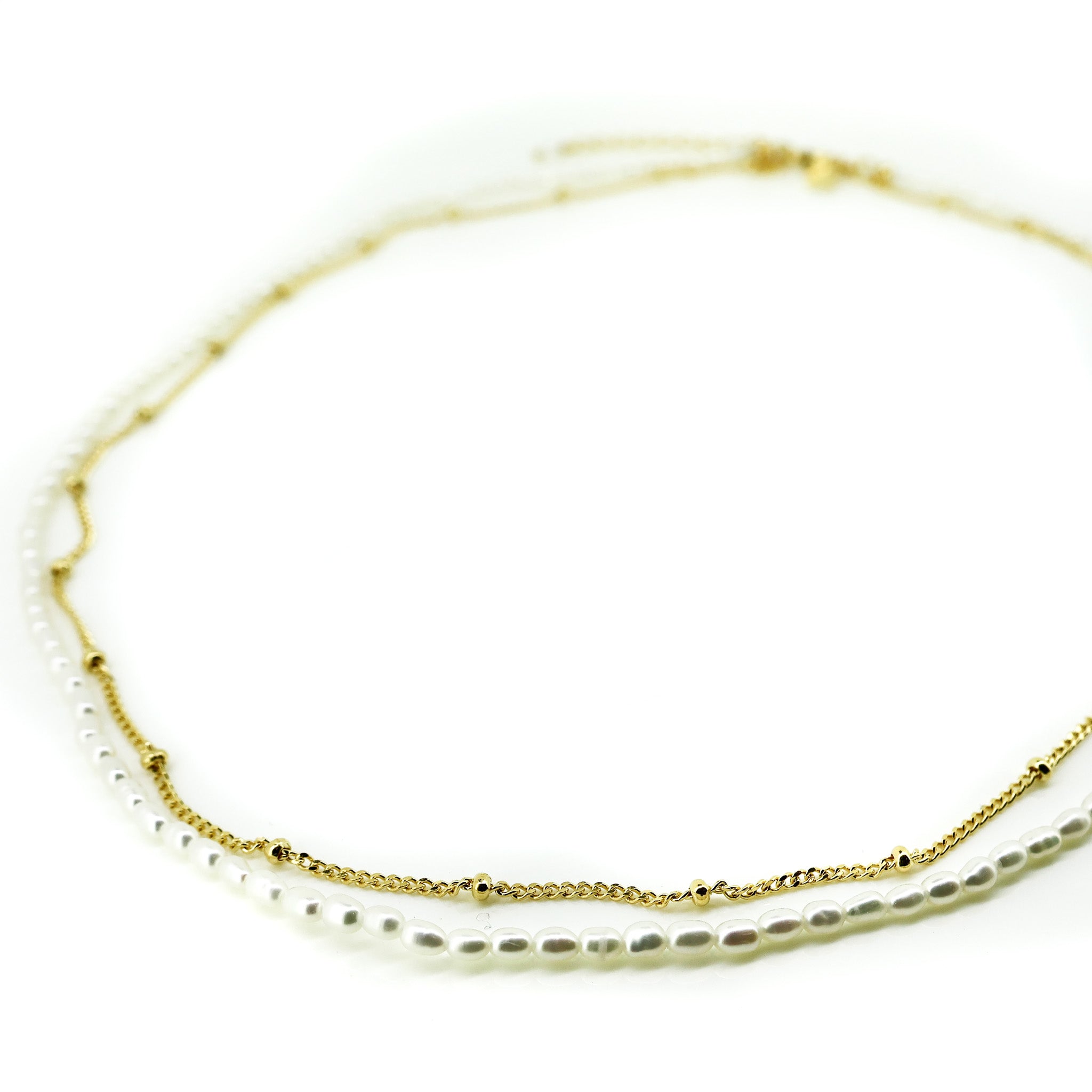 A delicate necklace featuring freshwater pearls layered with a gold vermeil chain, displayed against a white background.