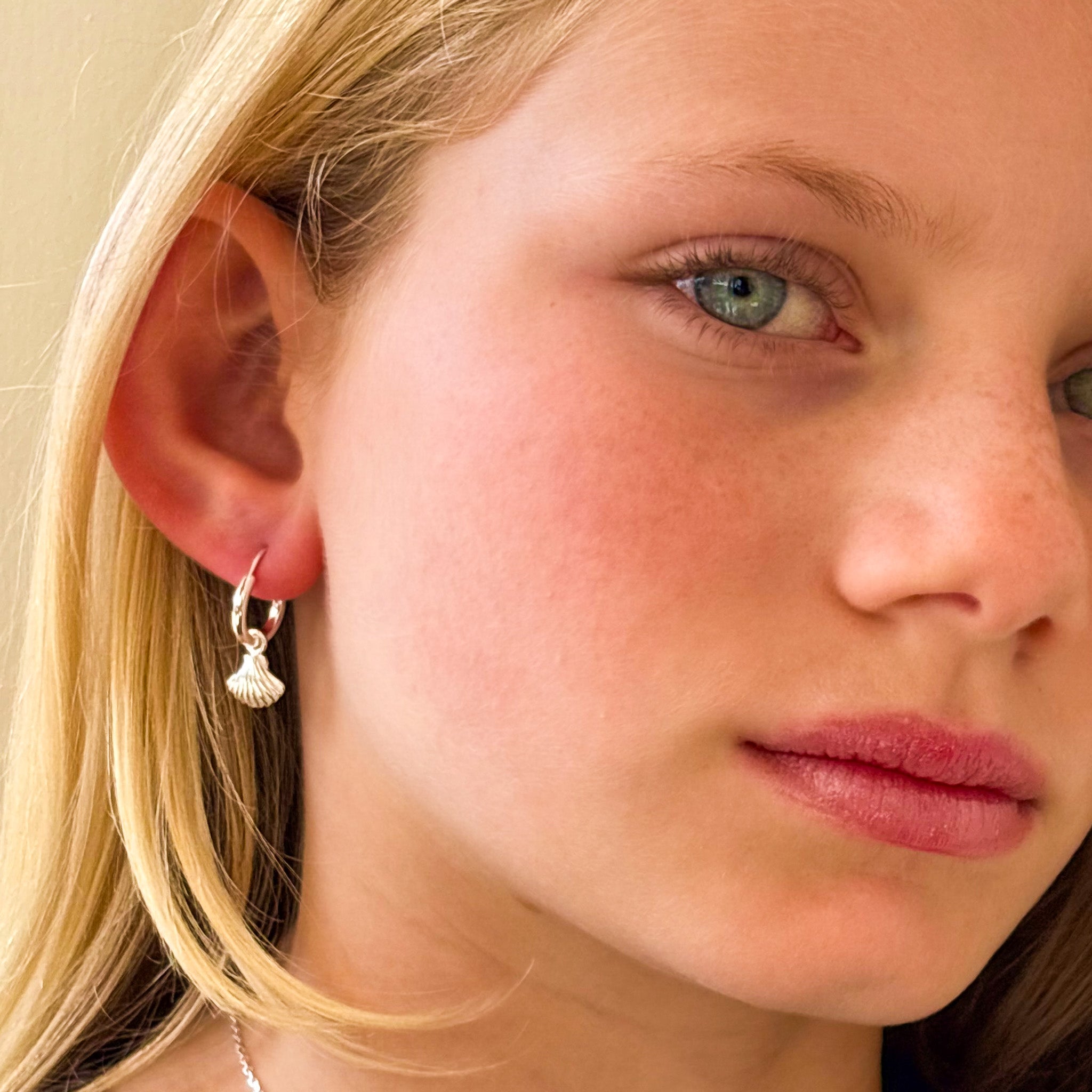silver sleeper huggie earrings with shell charm